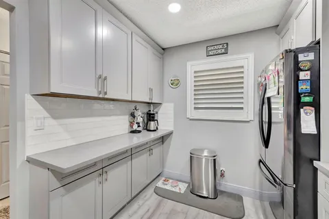 a kitchen with stainless steel appliances granite countertop a sink and a refrigerator