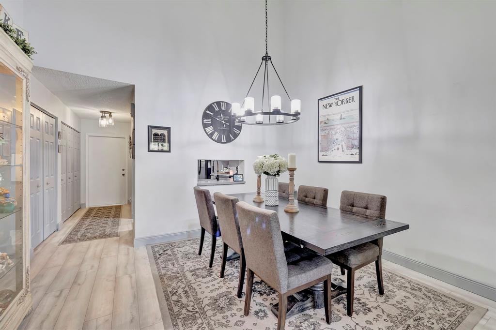 8799 Holly Court, Unit 202 Tamarac, FL 33321 - Photo 10 of 26 a view of a dining room with furniture a chandelier and wooden floor