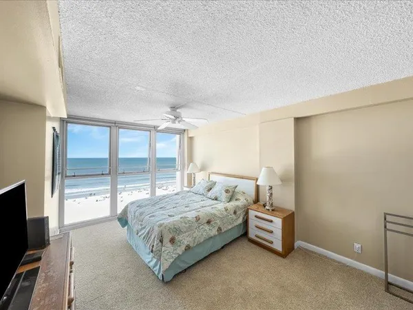 a bedroom with a bed and large windows