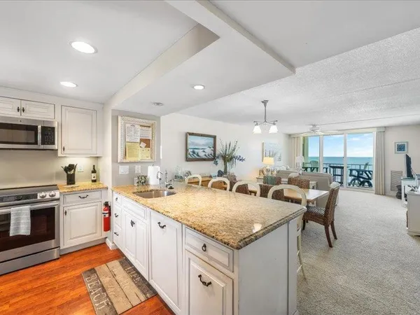 a kitchen with granite countertop a stove top oven sink and cabinets