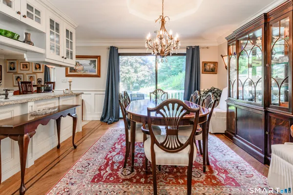 a view of a dining room with furniture a rug and wooden floor