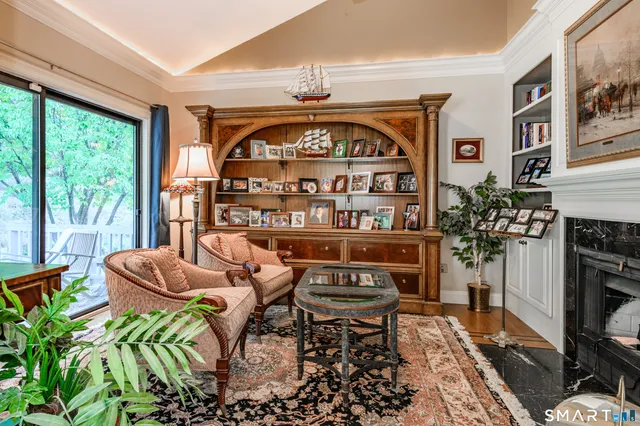 a living room with furniture a floor to ceiling window and a fireplace