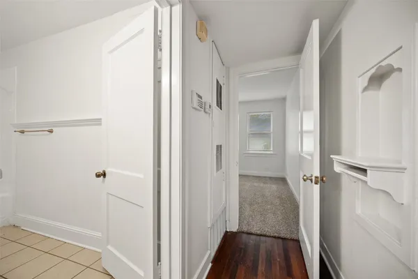 a view of a hallway with wooden floor and staircase