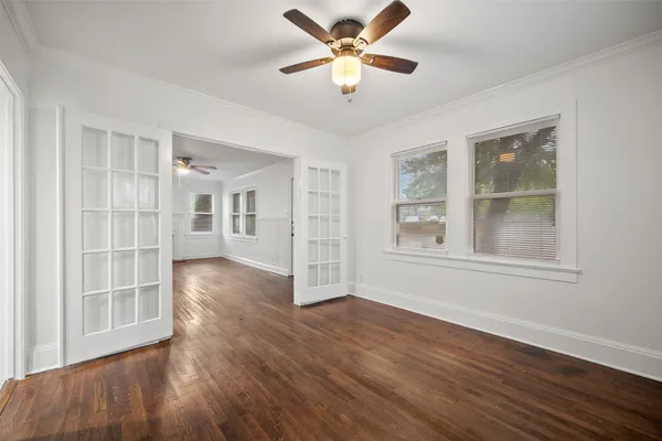 a view of an empty room with a window and wooden floor