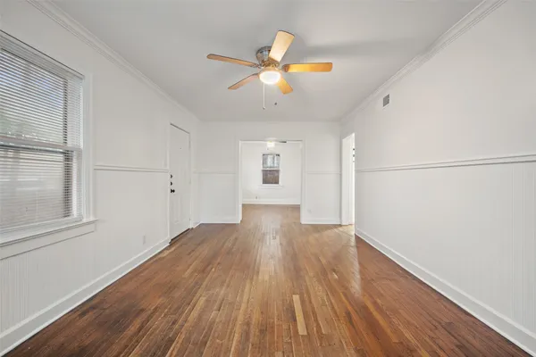 a view of empty room with wooden floor
