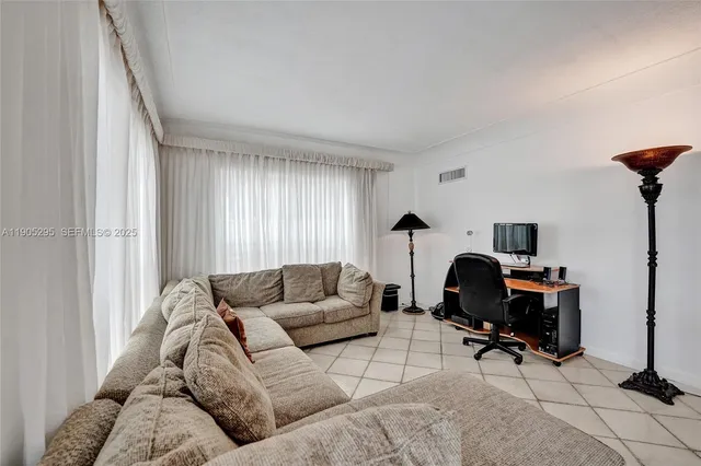 a living room with fireplace furniture and a large window