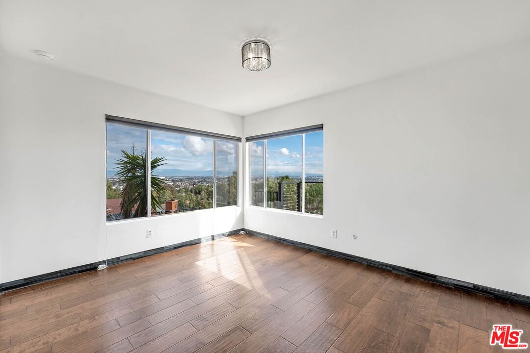 2050 Glentree Drive Lomita, CA 90717 - Photo 20 of 36 an empty room with wooden floor and windows