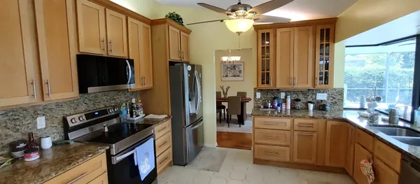 a kitchen with stainless steel appliances granite countertop a stove a sink dishwasher and a refrigerator