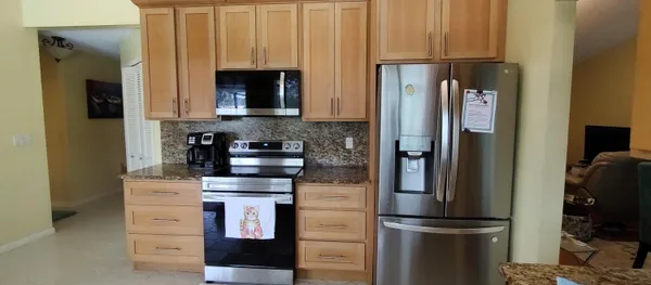 a kitchen with appliances a refrigerator and cabinets