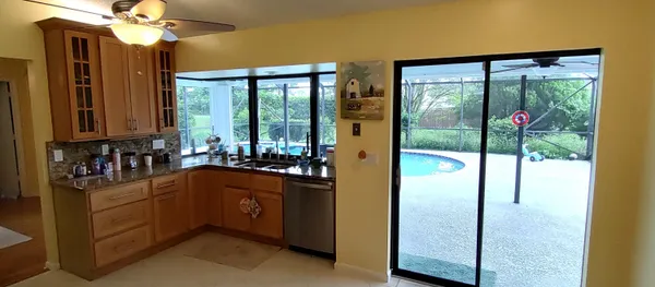 a kitchen with stainless steel appliances granite countertop a refrigerator a sink and a stove