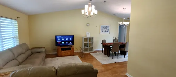 a living room with furniture a dining table and a chandelier
