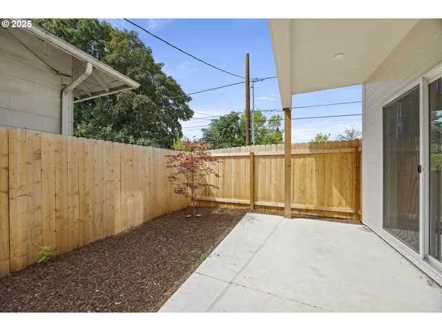 a view of a backyard with wooden fence