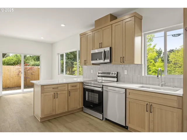 a kitchen with stainless steel appliances granite countertop a stove a sink dishwasher and a microwave