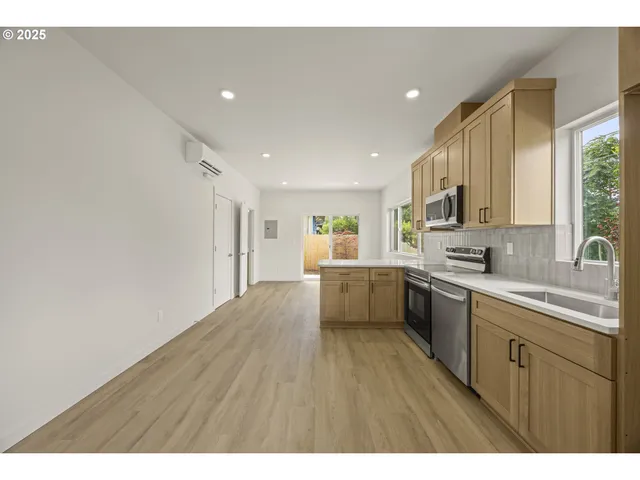 a kitchen with stainless steel appliances granite countertop a sink cabinets and wooden floor