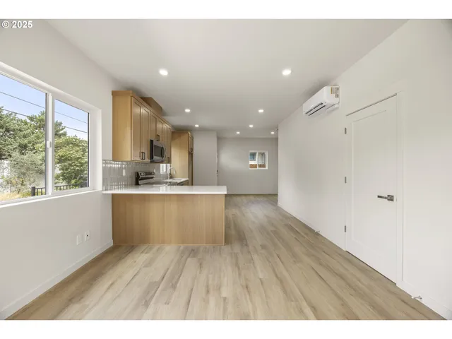 a open kitchen with white cabinets and wooden floor