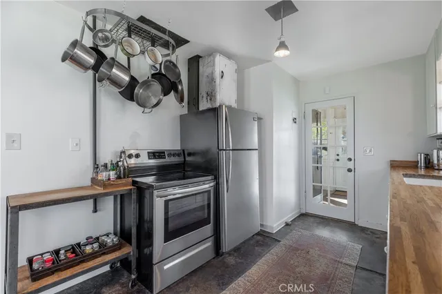 a kitchen with stainless steel appliances granite countertop a refrigerator a stove and a sink