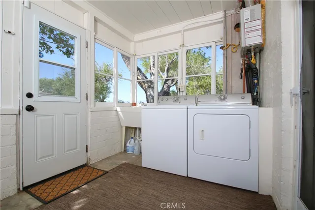 a view of a window and a utility room with wooden floor washer and dryer