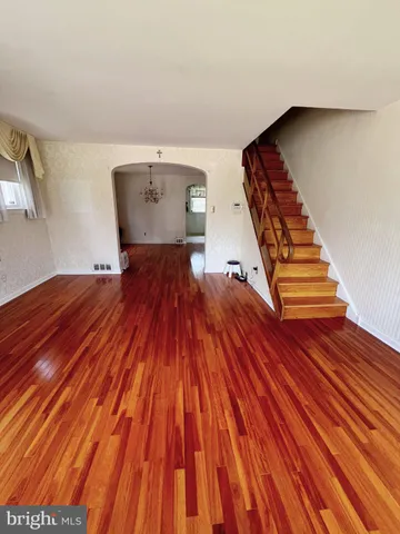 a view of a bedroom with wooden floor and stairs