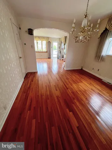 a view of a room with wooden floor and chandelier