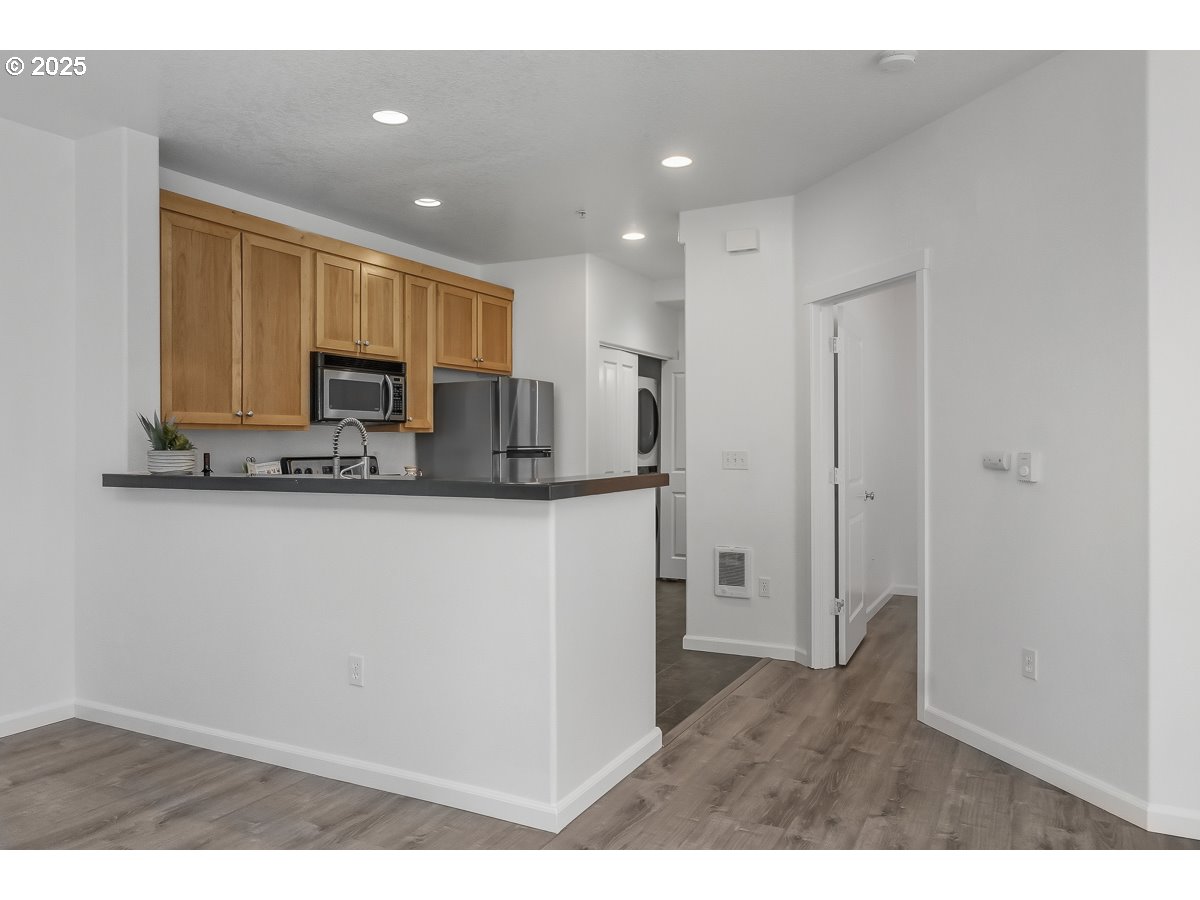 1180 Southwest 170th Avenue, Unit 100 Beaverton, OR 97003 - Photo 11 of 32 a kitchen with kitchen island a sink stainless steel appliances and cabinets