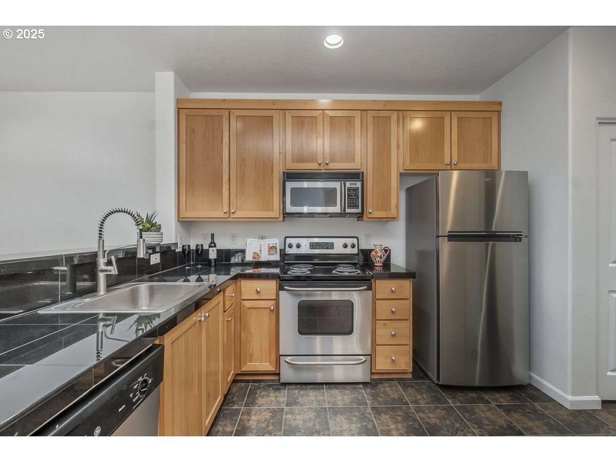 1180 Southwest 170th Avenue, Unit 100 Beaverton, OR 97003 - Photo 12 of 32 a kitchen with a refrigerator sink and stainless steel appliances