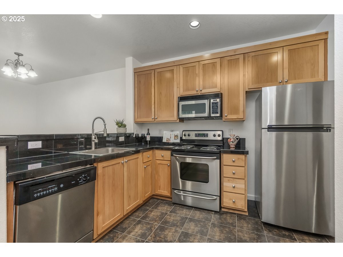 1180 Southwest 170th Avenue, Unit 100 Beaverton, OR 97003 - Photo 14 of 32 a kitchen with stainless steel appliances a sink cabinets and a refrigerator