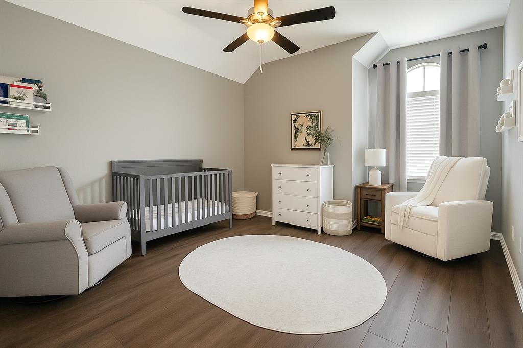 8557 Brittania Way Dallas, TX 75243 - Photo 10 of 18 Bedroom with a crib, wood finished floors, a ceiling fan, and vaulted ceiling