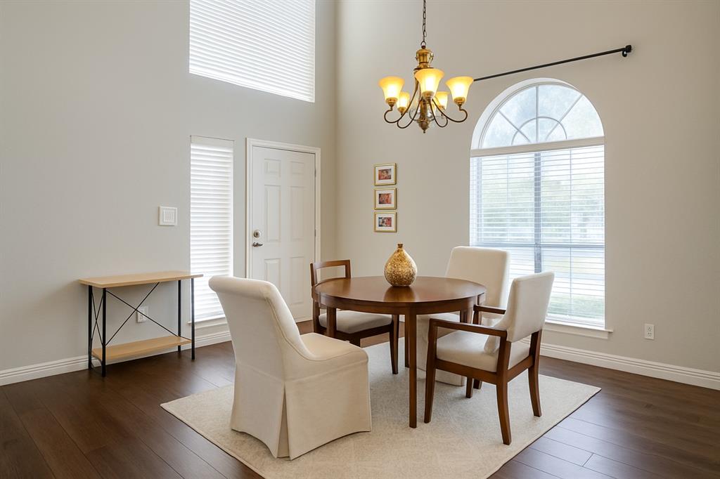 8557 Brittania Way Dallas, TX 75243 - Photo 2 of 18 Dining room with a towering ceiling, dark wood-type flooring, and a chandelier