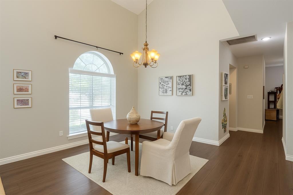 8557 Brittania Way Dallas, TX 75243 - Photo 4 of 18 Dining room with a chandelier, dark wood finished floors, and a high ceiling