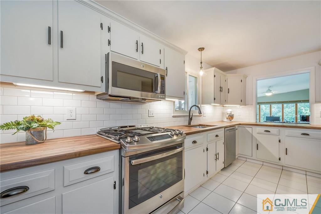 1 Ryan Road Cranbury, NJ 08512 - Photo 5 of 22 a kitchen with granite countertop white cabinets stainless steel appliances and a counter space