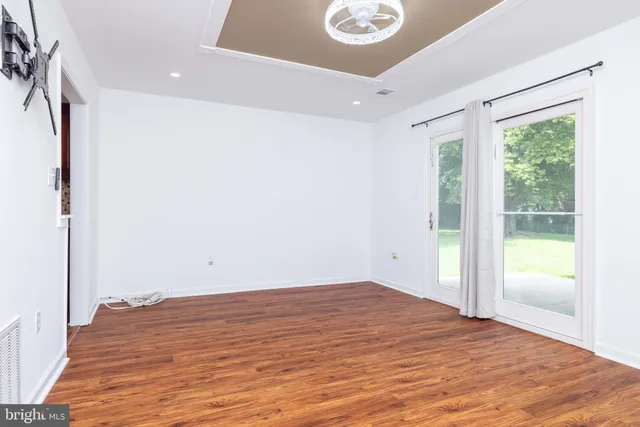 an empty room with potted plant and windows