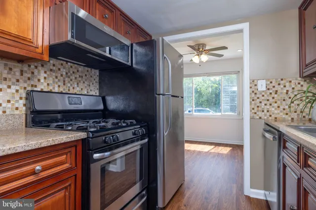 a kitchen with granite countertop wooden cabinets a sink and dishwasher