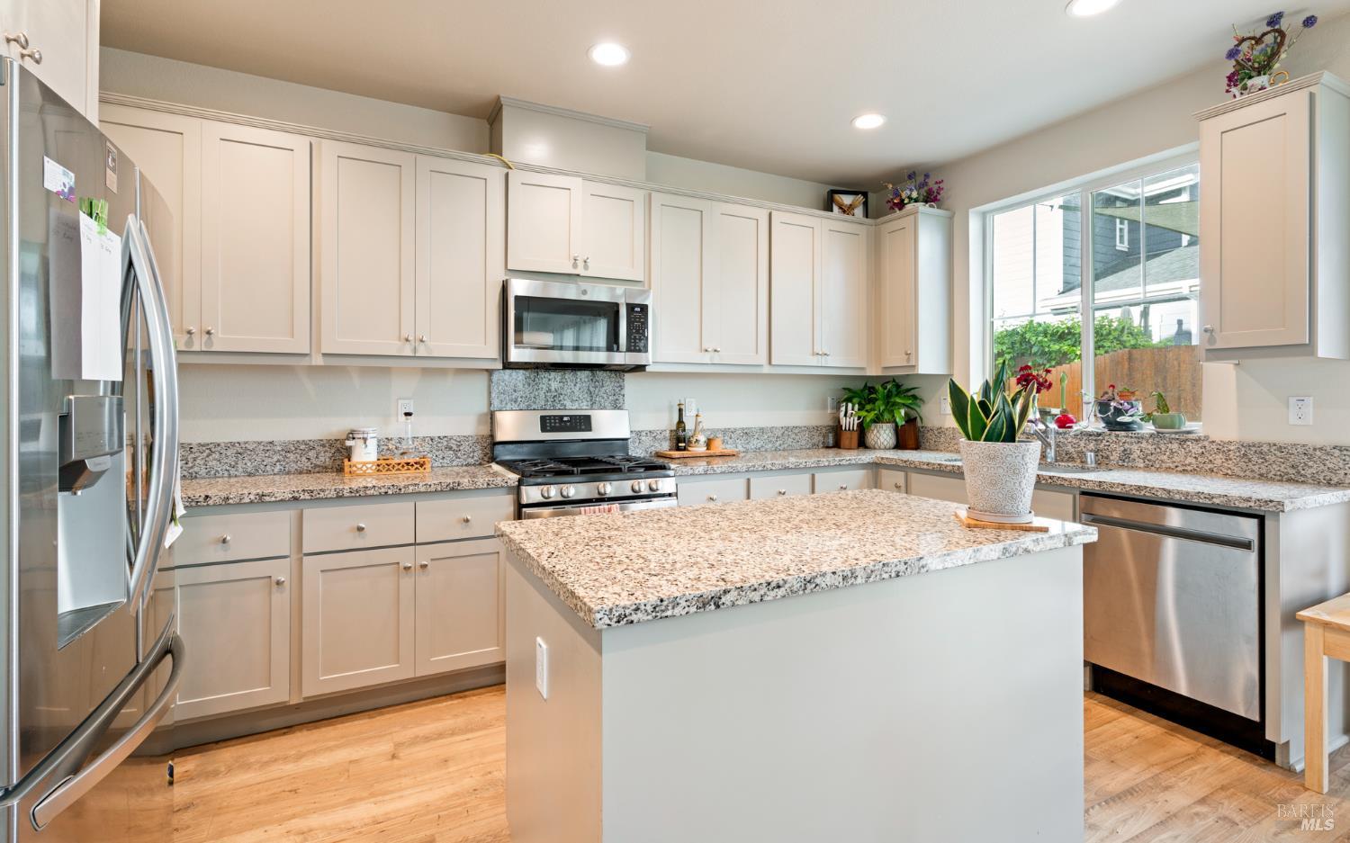 1461 Cecilia Drive Santa Rosa, CA 95401 - Photo 2 of 20 a kitchen with granite countertop a sink stainless steel appliances and white cabinets