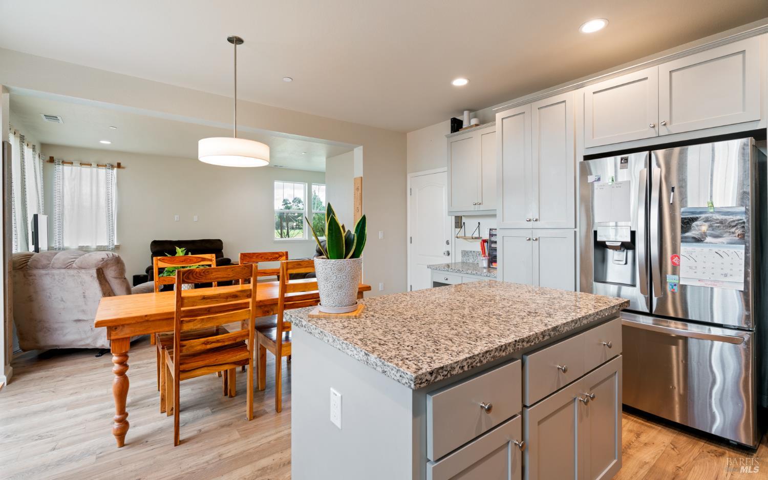 1461 Cecilia Drive Santa Rosa, CA 95401 - Photo 4 of 20 a kitchen with a table chairs refrigerator and wooden cabinets