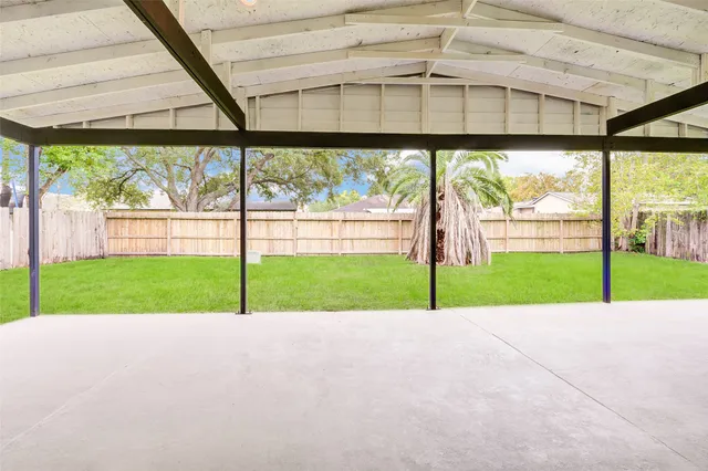 a view of yard with deck area and glass door