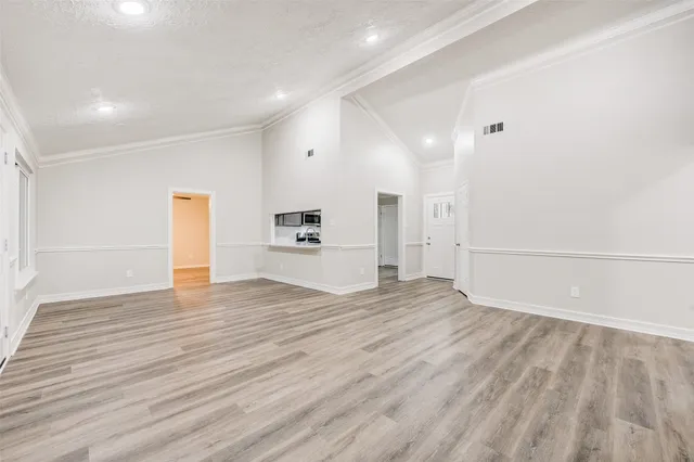 a view of empty room with wooden floor