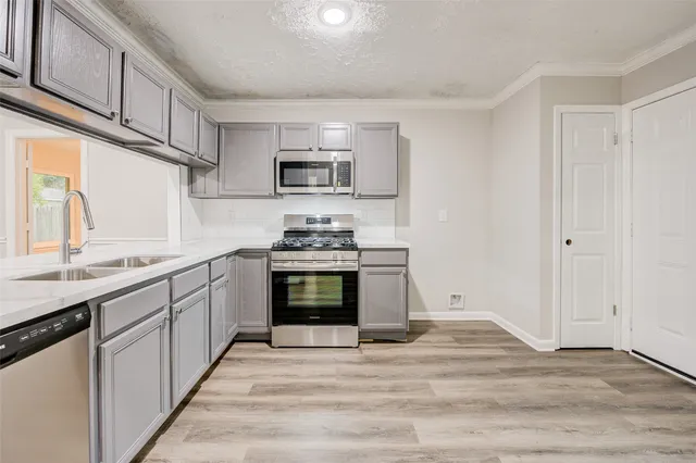 a kitchen with stainless steel appliances a stove microwave and cabinets