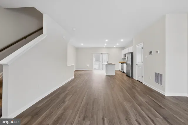 a view of a kitchen with wooden floor and a window