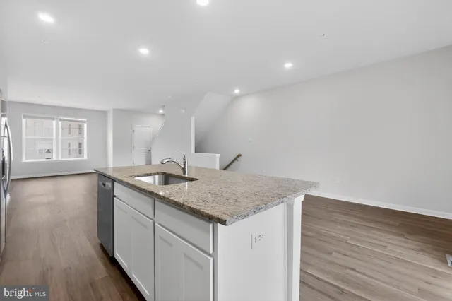 a bathroom with a granite countertop sink and a large mirror