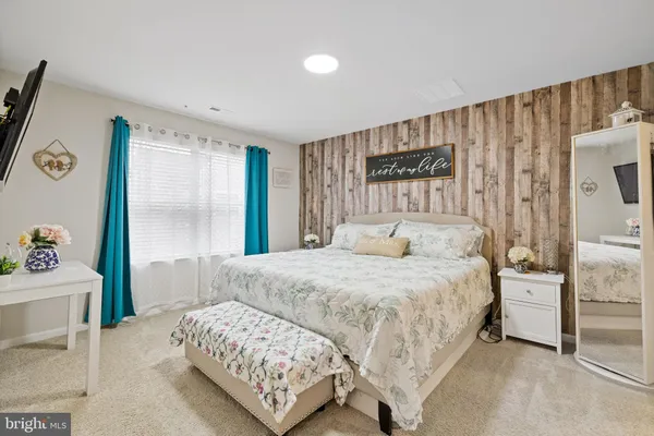 a bedroom with a bed and a painting on the wall