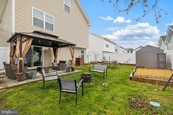 a view of a house with backyard sitting area and garden