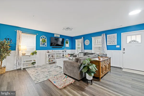 a living room with furniture and a wooden floor