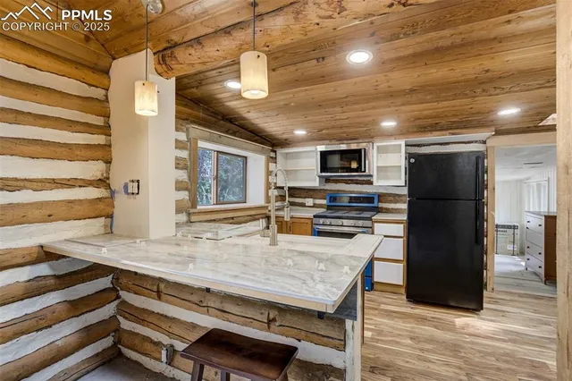 a kitchen with a stove a refrigerator and a microwave