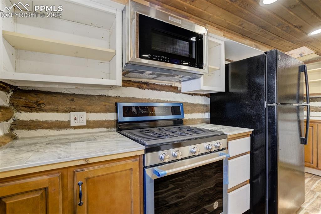 4560 Canonwood Road Colorado Springs, CO 80906 - Photo 15 of 50 a kitchen with a stove microwave and refrigerator