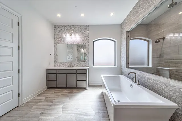 an empty room with a chandelier fan and windows