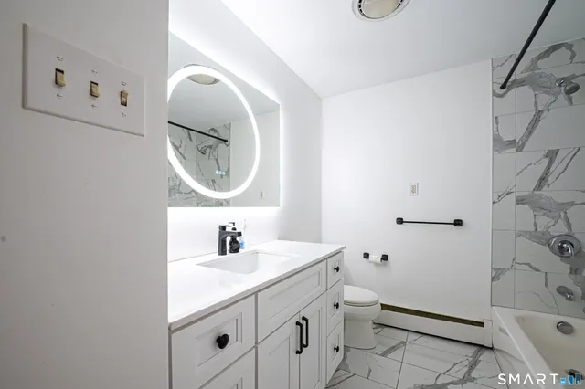 a bathroom with a sink mirror and toilet