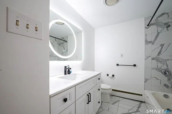 a bathroom with a toilet sink vanity and mirror