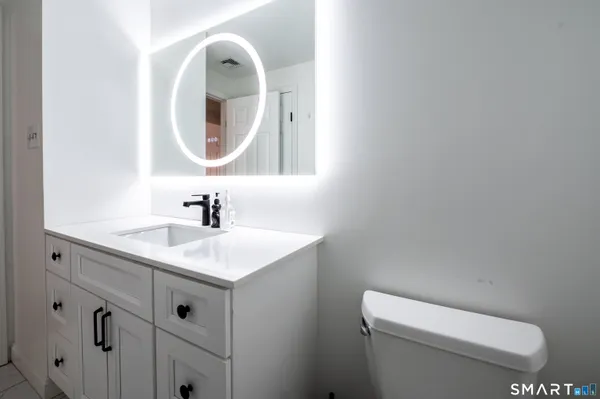 a bathroom with a sink a toilet and a mirror