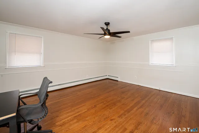 a view of a workspace with wooden floor and a window