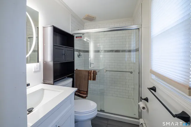 a bathroom with a sink a toilet and shower